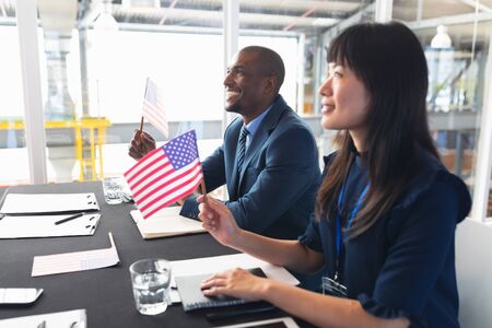 Side view of diverse Business people sitting at conference registration table. International diverse corporate business partnership conceptの写真素材