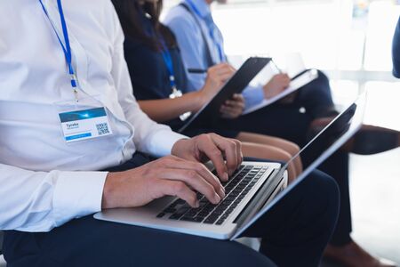 Close-up of caucasian Businessman using laptop while attending business seminar. International diverse corporate business partnership conceptの写真素材