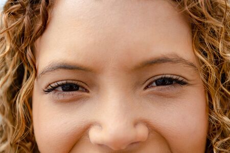 Close-up of happy mixed-race woman looking at camera. Summer fun at home by the swimming pool