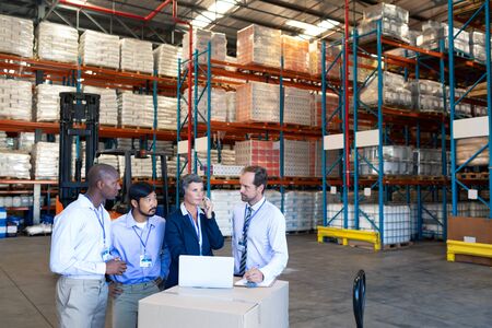 Front view of diverse staff discussing with each other in warehouse. This is a freight transportation and distribution warehouse. Industrial and industrial workers conceptの写真素材