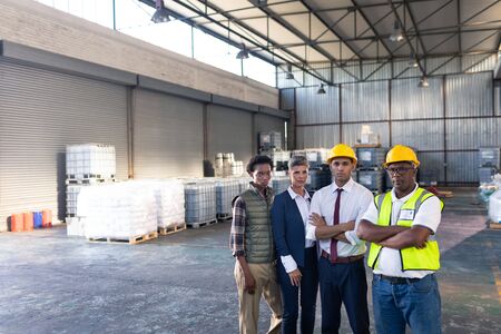 Portrait of diverse male and female staffs standing together in warehouse. This is a freight...