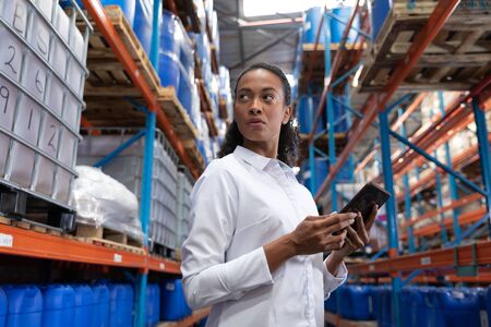 African American female manager using digital tablet in warehouse. This is a freight transportation and distribution warehouse. Industrial and industrial workers conceptの写真素材