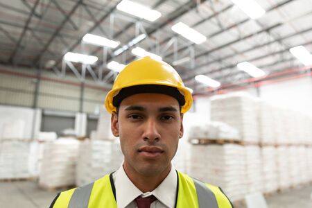 Close-up of male worker looking at camera in warehouse. This is a freight transportation and...