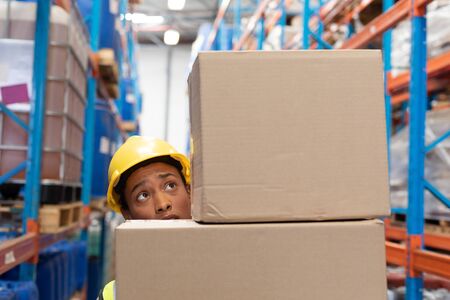 Female worker carrying cardboard boxes in warehouse. This is a freight transportation and...