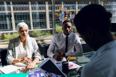 Male and female executives working together on computer at desk in office. Modern corporate start up...