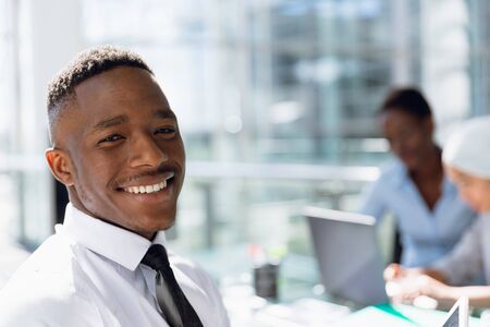 Portrait of happy Businessman sitting at desk in office. Modern corporate start up new business...