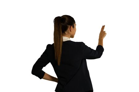 Back view close up of a young mixed race businesswoman with hand on hip and one arm raised with hand up and two fingers extended, touchingの写真素材