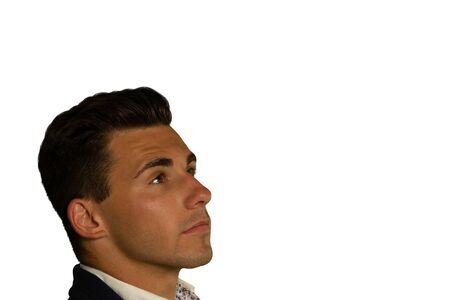 Side view headshot of a young Caucasian businessman wearing a black jacket and white shirt, looking...