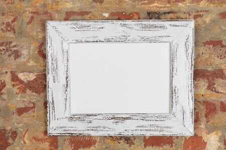 Blank framed picture hanging on a brick wall