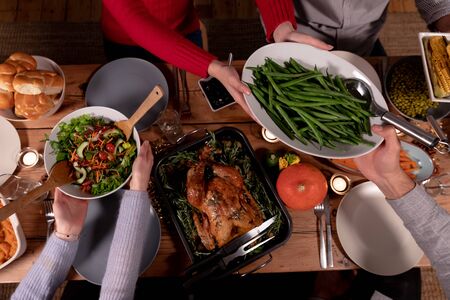 High angle view of a group of young adult multi-ethnic male and female friends sitting around a...