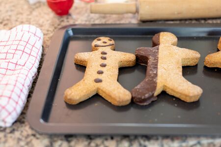 Front view close up of Christmas gingerbread man cookies on a baking tray on the worktop of the...