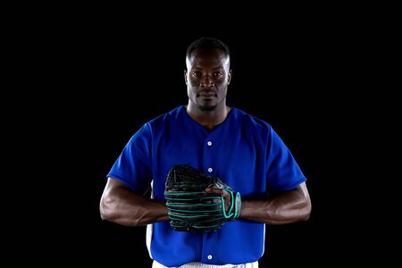 Portrait of an African American male baseball player, a pitcher or fielder, wearing a team uniform...