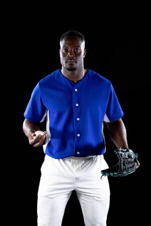 Portrait of an African American male baseball player, a pitcher or fielder, wearing a team uniform...