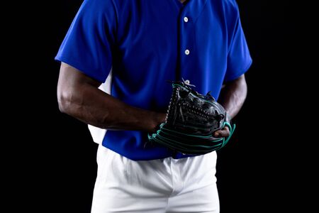 Front view mid section of an African American male baseball player, a pitcher or fielder, wearing a...