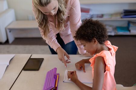 Front view of a Caucasian female elementary school teacher with long blonde hair standing in a...