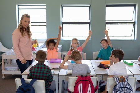Front view of a Caucasian female elementary school teacher with long blonde hair standing in a...
