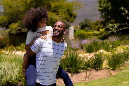 Weekend fun at home together. Front view of a mixed race couple standing in the garden, looking at...
