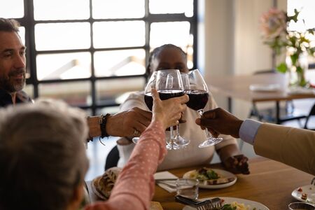 Side view of senior multi-ethnic group at cookery class, sitting at a table relaxing together,...