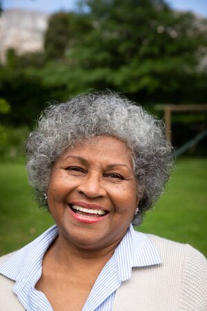 Portrait close up of smiling senior African American woman in a garden looking at camera.