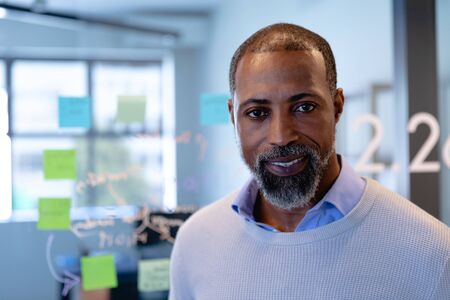 Portrait of a mixed race man wearing smart clothes, working in a modern office, smiling and looking straight into a camera.の写真素材