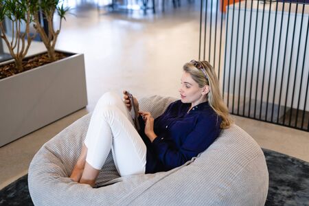 Front view of a Caucasian businesswoman wearing smart clothes, working in a modern office, sitting...