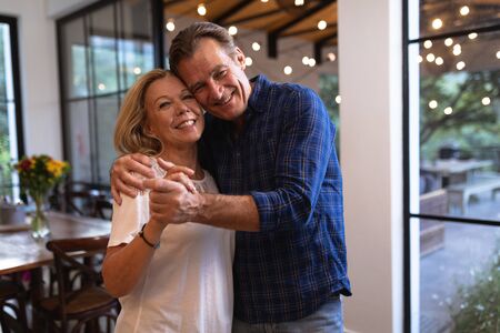 Senior Caucasian couple enjoying their time at home together, dancing in a kitchen and smiling, social distancing and self isolation in quarantine lockdown during coronavirus covid19 epidemicの写真素材