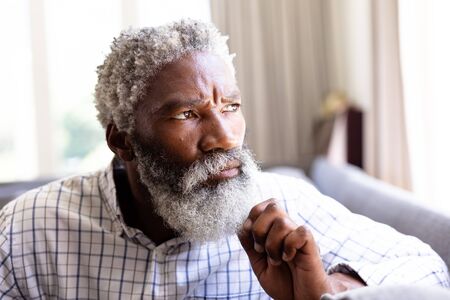 Portrait of a senior African American man enjoying his time at home, sitting on a couch, looking...
