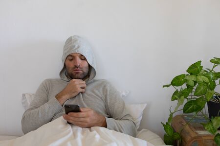 Sick Caucasian man at home self isolating and social distancing in quarantine lockdown during...
