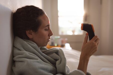 Sick Caucasian woman spending time at home self isolating and social distancing in quarantine...