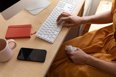 Mid section of Caucasian woman spending time at home self isolating and social distancing in...