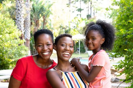 Senior African American woman spending time with her daughter and her granddaughter in the garden on...
