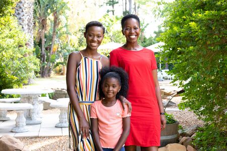 Senior African American woman spending time with her daughter and her granddaughter in the garden on...