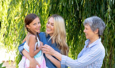 Senior Caucasian woman spending time with her daughter and her granddaughter in the garden on a...