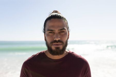 Portrait of a Mixed race man enjoying his time at the beach with his friends on a sunny day, looking at the cameraの写真素材
