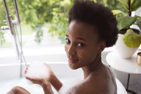 Mixed race woman spending time at home self isolating and social distancing in quarantine lockdown...