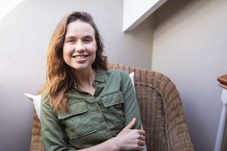 A portrait of a happy, Caucasian woman spending time at home, sitting on a chair. Lifestyle at home...