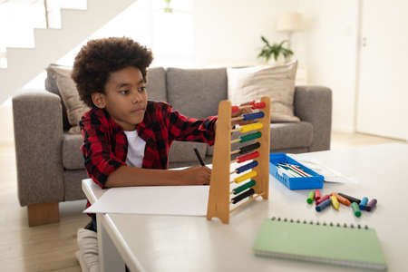 Mixed race boy enjoying family time together at home, social distancing and self isolation in...