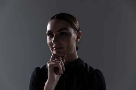 Portrait of an attractive confident Caucasian professional woman with long dark hair in a tidy bun...