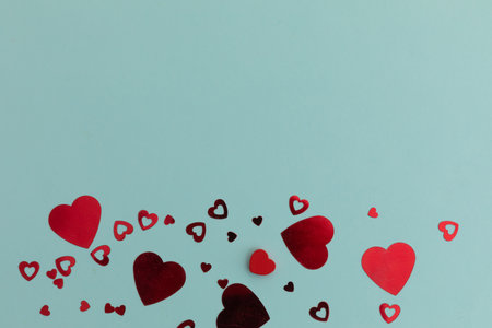 High angle view of red metallic hearts on blue background. valentine&#39;s day romance love gift copy space concept.の写真素材