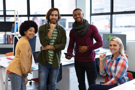 Diverse group of business people working in crative office. portrait of group of people looking at...