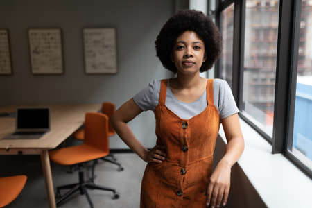 Mixed race businesswoman working in creative office. portrait of a woman looking at camera. social distancing in workplace during covid 19 pandemic.の写真素材