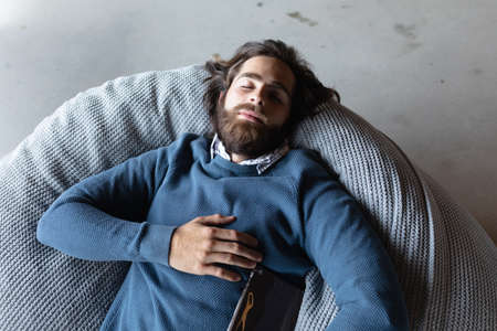 Caucasian businessman working in creative office. man resting after work and holding tablet. social...