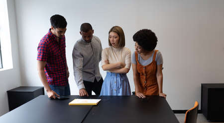 Diverse group of business people working in creative office. group of people standing and discussing...