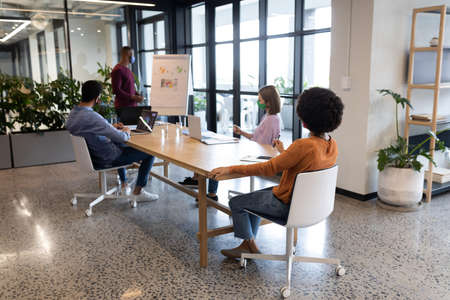 Diverse group of business people working in creative office. group of people in a meeting discussing...