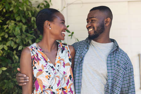 Portrait of smiling african american couple embracing in the garden. staying at home in isolation...