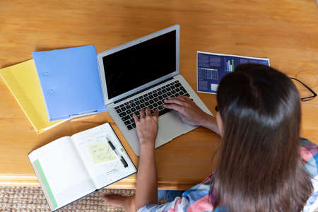 Caucasian woman sitting by desk working from home using laptop. staying at home in isolation during...