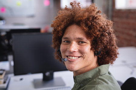 Portrait of happy mixed race businessman having video call wearing headphones. independent creative...