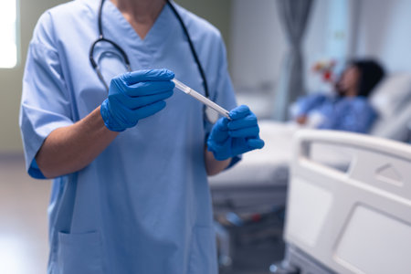 Midsection of caucasian female doctor in hospital wearing surgical gloves holding swab test. medical...
