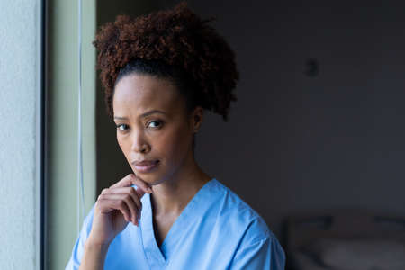 Portrait of african american female doctor in hospital patient room looking to camera. medicine, health and healthcare services.の写真素材