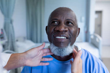 Caucasian female doctor palpating lymph nodes of african american male patient. medicine, health and healthcare servicesの写真素材